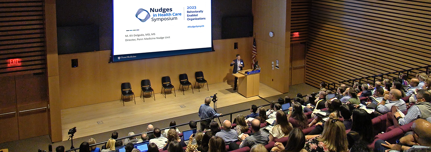 Kit Delgado addresses the auditorium audience at the 2023 symposium
